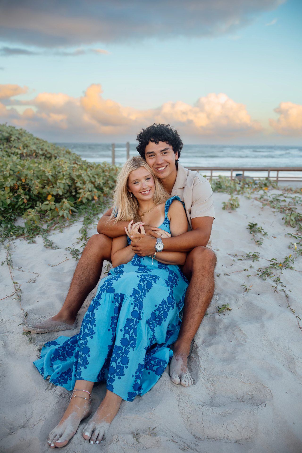 Couple seated in the sand at sunset