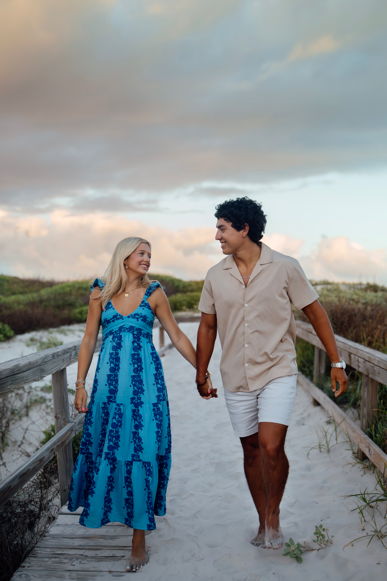 Couple walking through the dunes at sunset